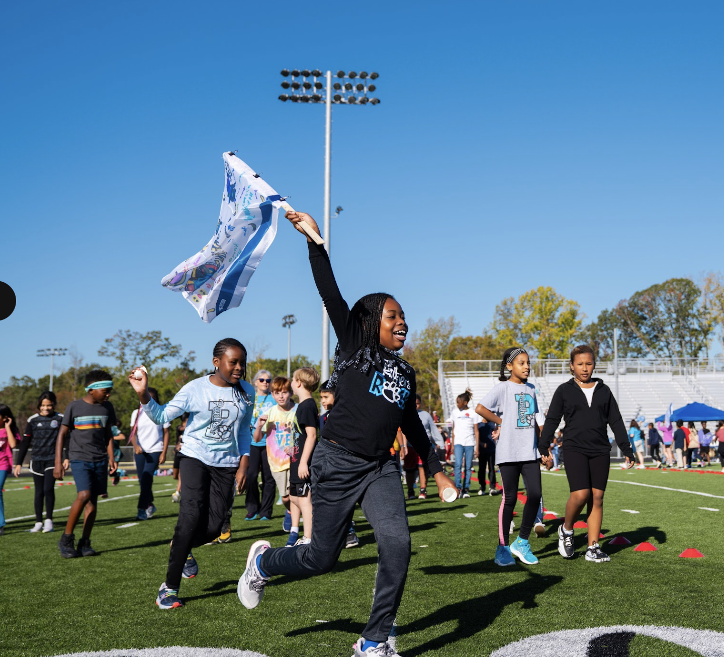 Student running with a flag at a Booster fundraising event