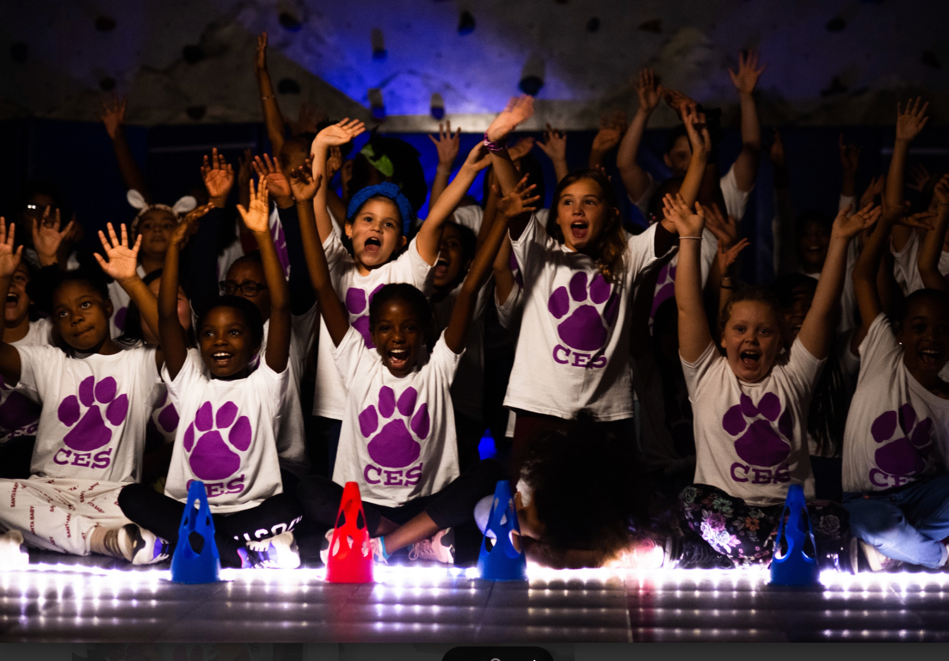 Students cheering with arms raised at a Booster event