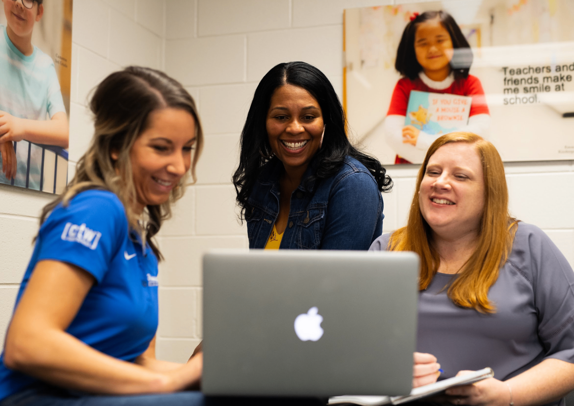 Teachers collaborating around a laptop